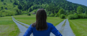 Businesswoman at crossroads in naturalistic environment.