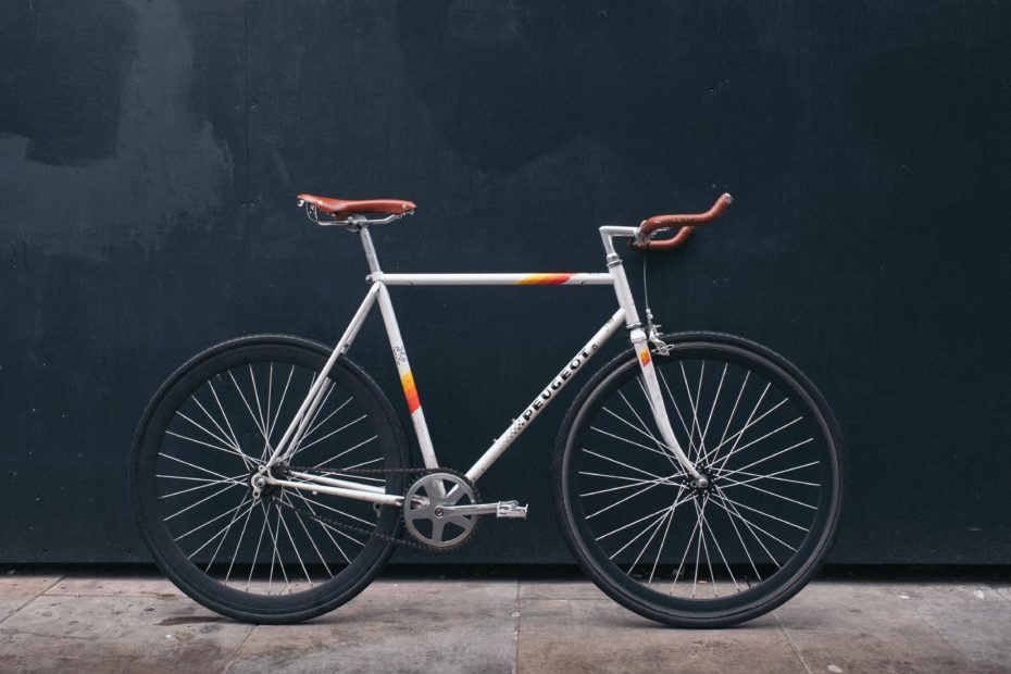 Traditional single speed bike seen from the side with a dark wall in the background