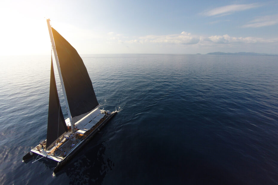 Birds-eye angle of a Yacht sailing in open sea at windy day, representing innovation navigating uncertainty.