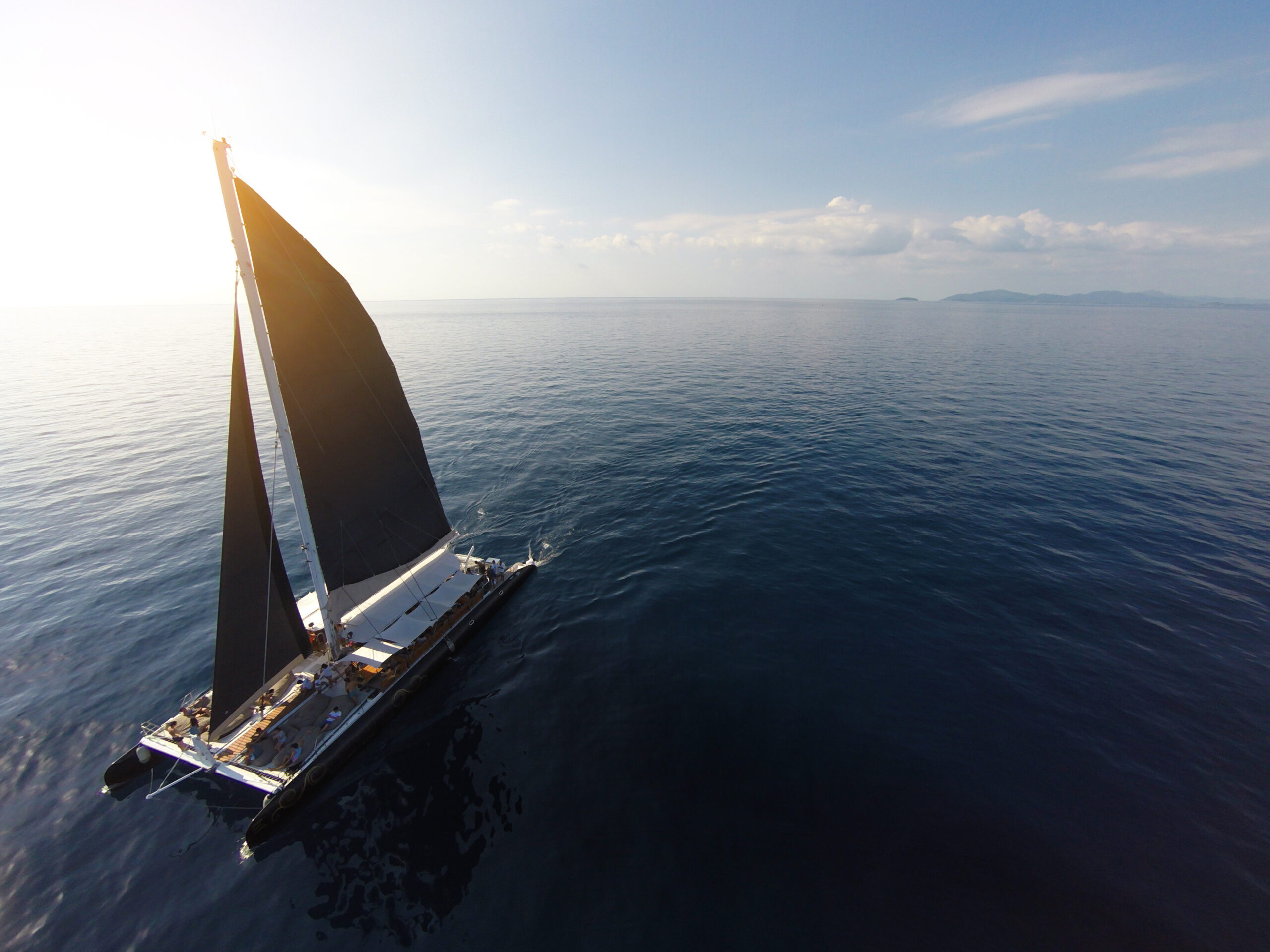 Birds-eye angle of a Yacht sailing in open sea at windy day, representing innovation navigating uncertainty.