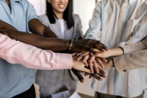 Diverse product team members stacking their hands together in a show of teamwork and collaboration.