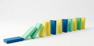 Dominoes falling in a chain reaction, illustrating how product risks can cascade and threaten an entire business.